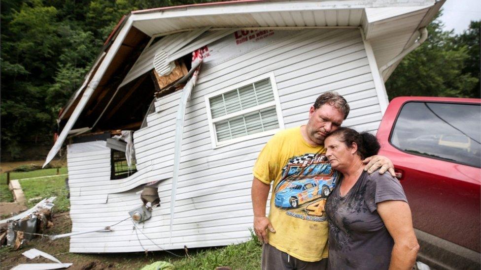 A couple outside their destroyed home