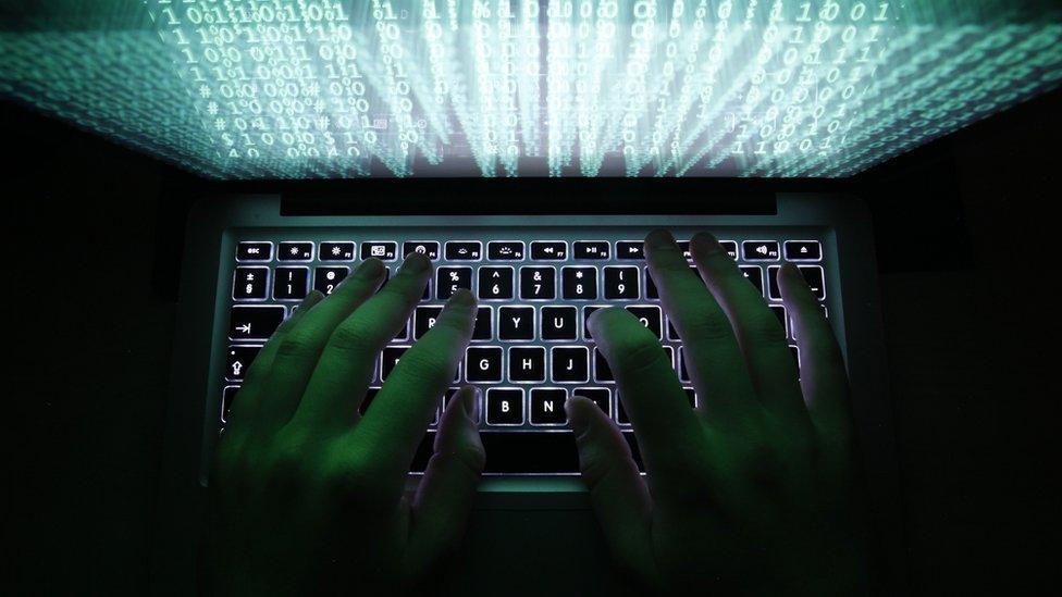 Man typing on a computer keyboard