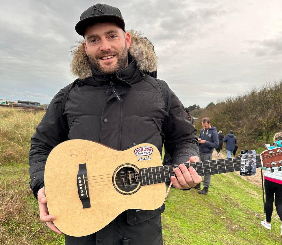 Nathan Adams and his guitar signed by Ed Sheeran