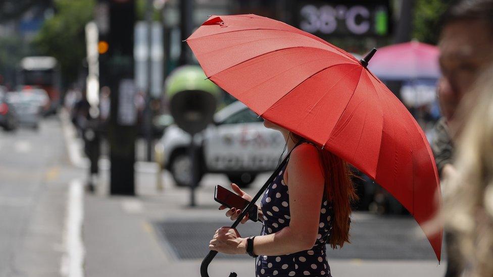 A woman protects herself from the sun in Sao Paulo