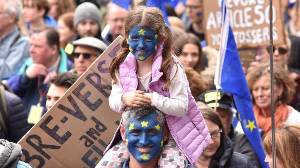 Child shown with EU flag painted on their face at the protest march