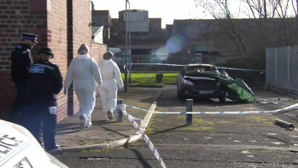 Officers investigating a burnt-out car