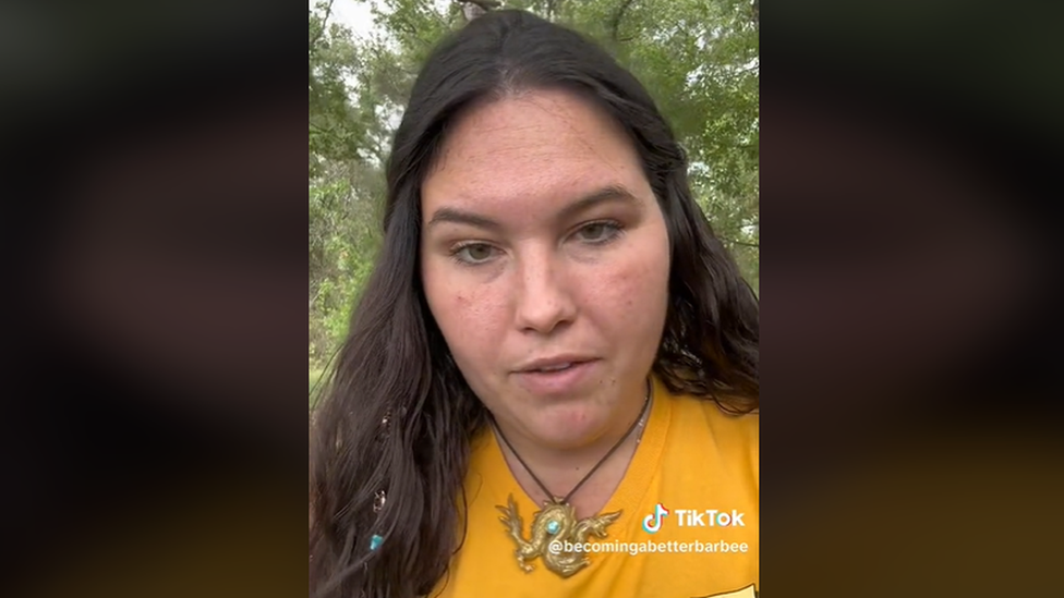 A screengrab shows Jenna Barbee in the video she posted to TikTok. She has long dark hair and is wearing a yellow t-shirt.