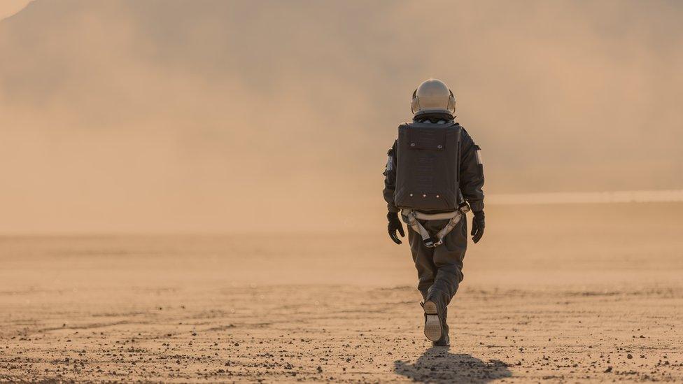 An artist impression of an astronaut walks on Mars surface