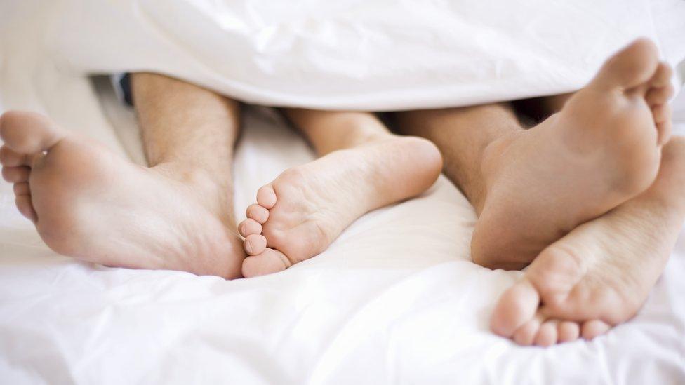 Couple's feet in bed