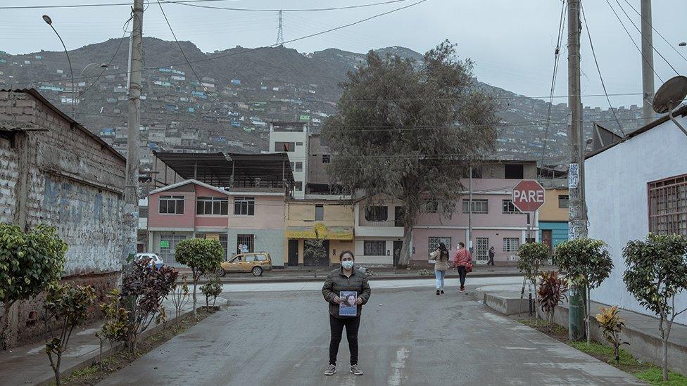 Jessica Quesada (30) carries a photo of her sister-in-law Alison Fernandez (30), who went out to the local market on the morning of August 13th and did not return home