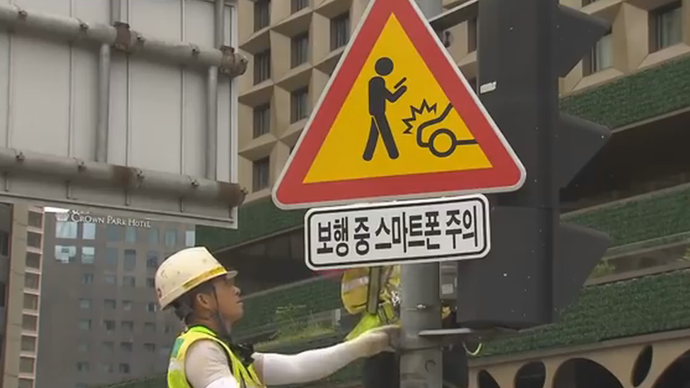 A workman installing one of the signs