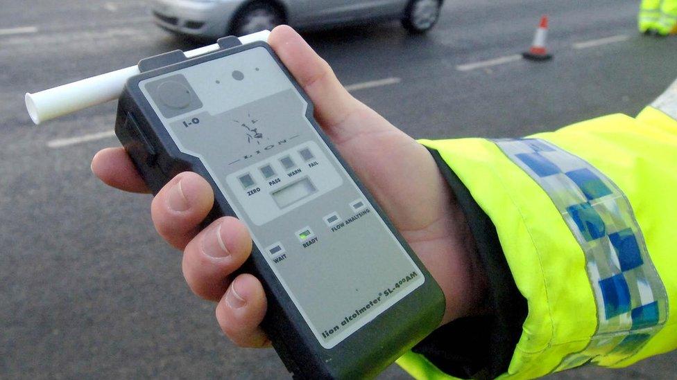 police officer holds a breath test kit