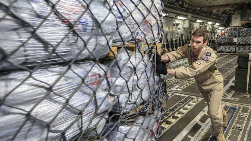 A British Aid worker unloads a plane