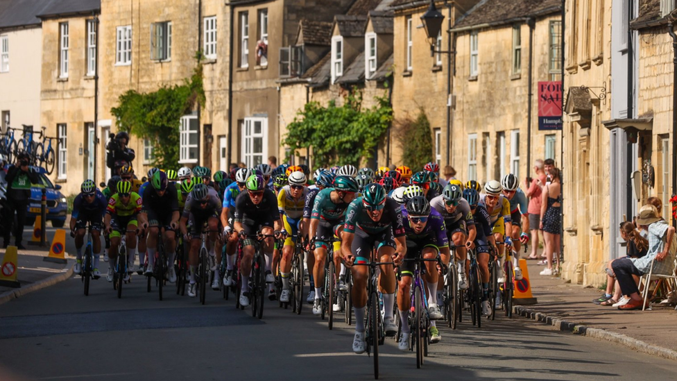 A group of cyclists riding through a village