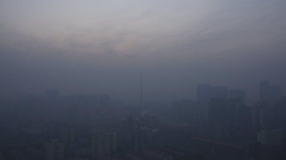 A chimney is seen near residential buildings amid heavy smog under a red alert for air pollution, in Beijing, China, December 19, 2015.