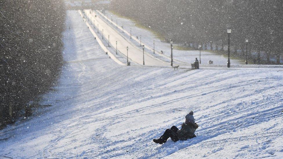 Someone sledging down a slope