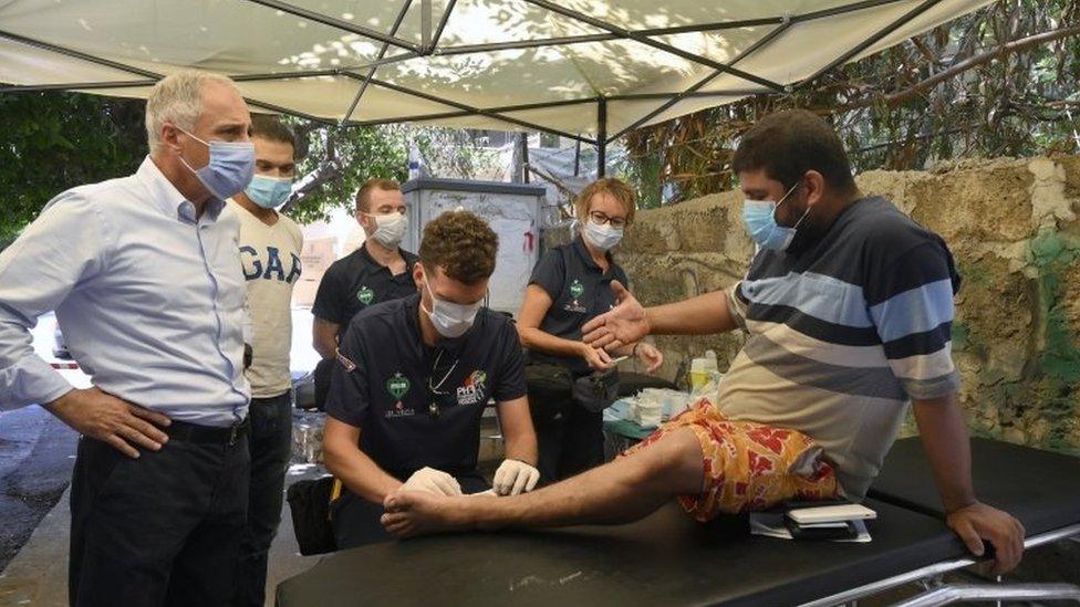 A French doctor from Pompiers Humanitaires Francais (PHF) treats a man in front of the Wardieh Hospital at Gemmayze street in Beirut, Lebanon (11 August 2020)