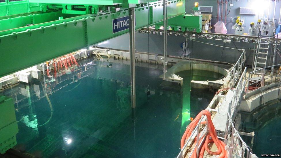 In this handout image provided by Tokyo Electric Power Co, workers remove nuclear fuel rods from a pool at No. 4 reactor of the Fukushima Daiichi Nuclear Power Plant on 18 November 2013 in Okuma, Fukushima, Japan.