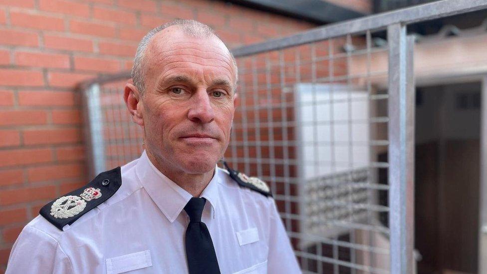 Chief Constable Mark Hobrough, the National Police Chief Council's lead for dangerous dogs is pictured in his police uniform outside a metal gate.