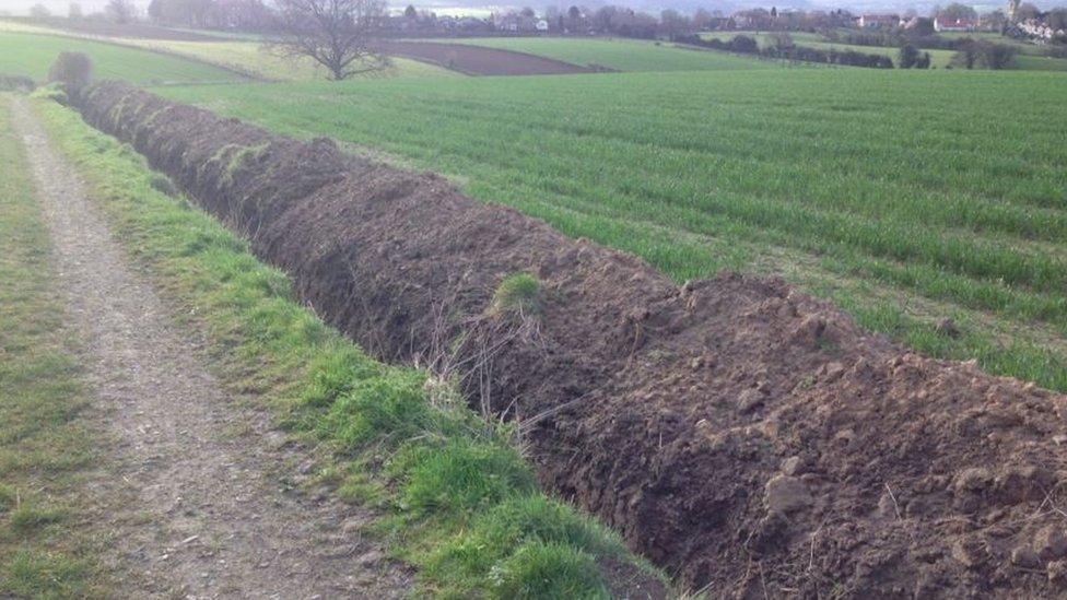 Trench dug at edge of field