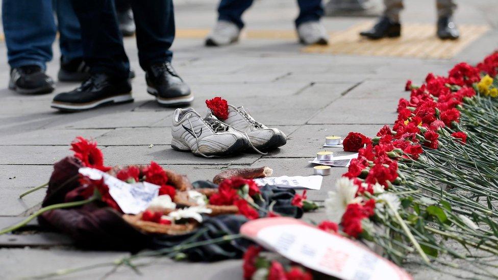 People place flowers and shoes on the ground after a twin bombing in Ankara, Turkey (12 October 2015)