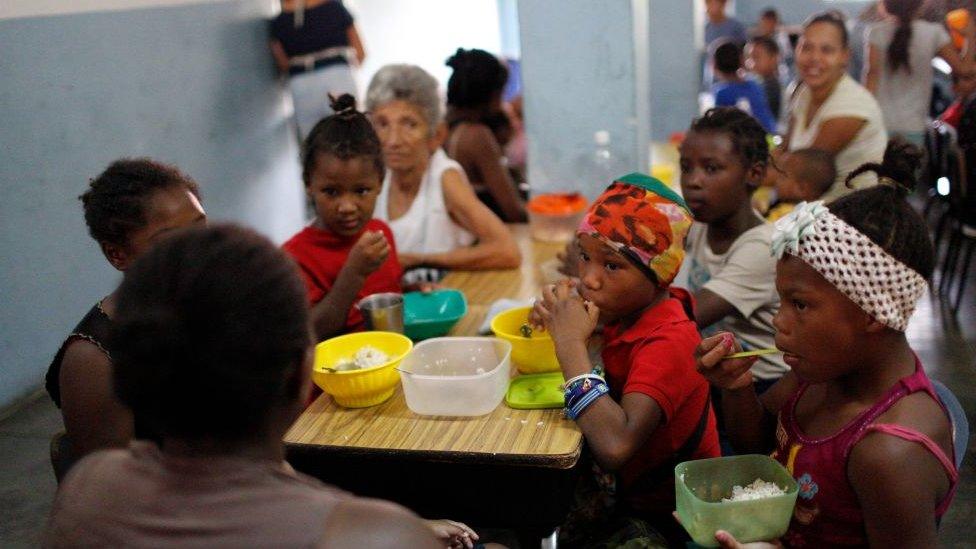 Children eat lunch at Madre Asuncion's community kitchen on October 9, 2019 in Petare, Caracas, Venezuela.