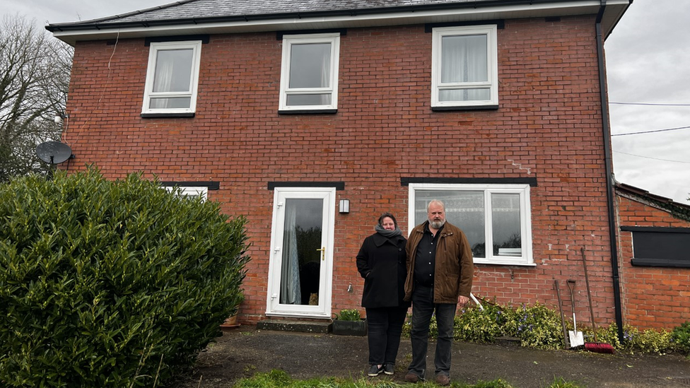 Anna and Paul stood outside their house