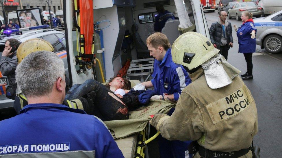 An injured person is helped into an ambulance by emergency services outside Sennaya Ploshchad metro station following explosions in St Petersburg, Russia, 3 April 2017