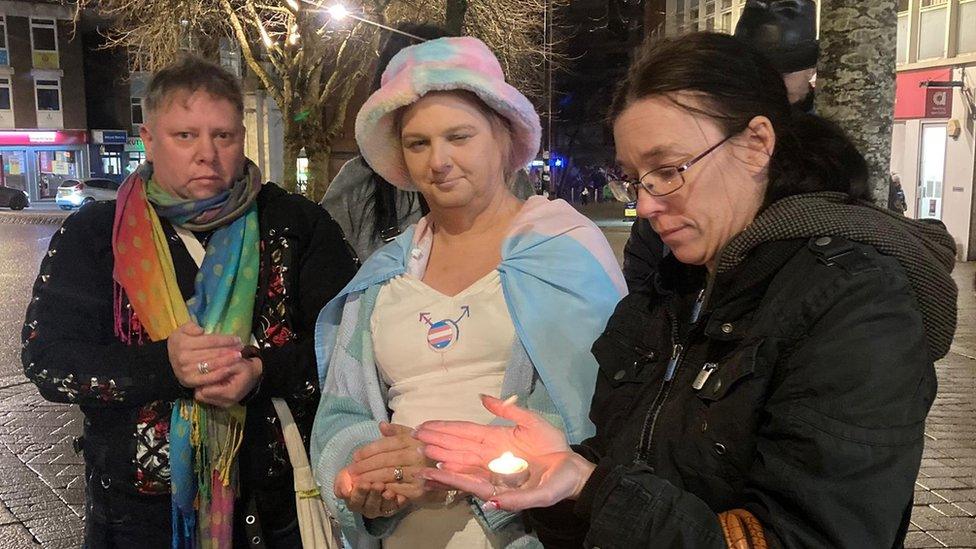 People lighting candles at the vigil