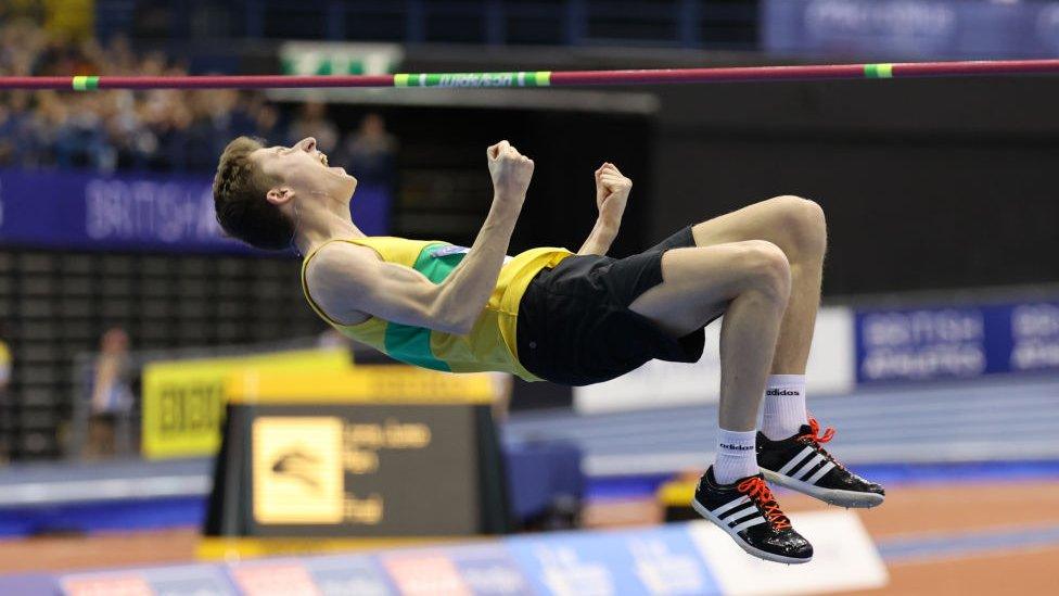 Tom Hewes punches the air in celebration at a winning jump