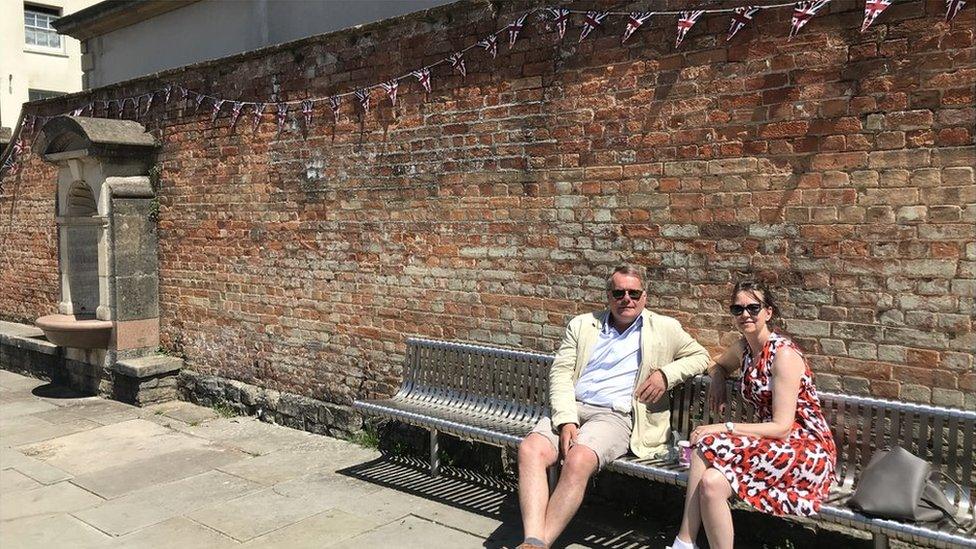 Homeworkers Fergus and Fiona sitting on a bench in the sun in Langport