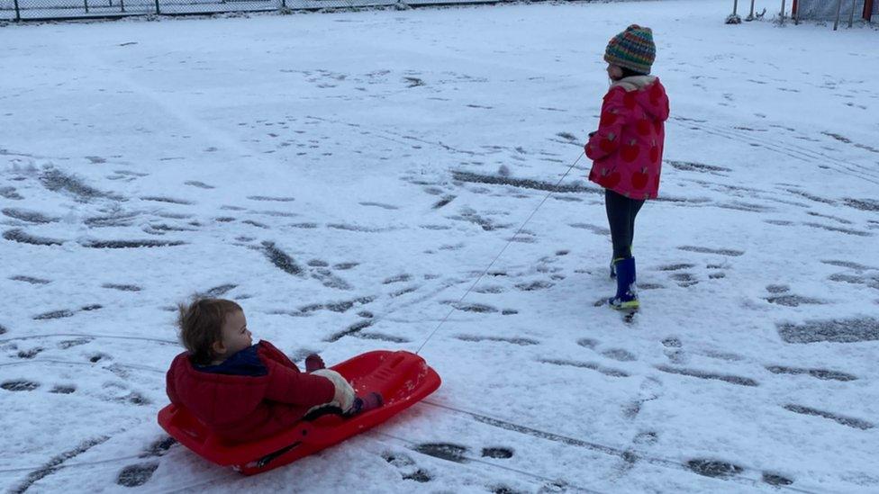 Two children sledging.