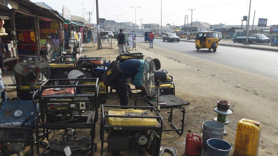 A roadside mechanic repairs electricity generators that are believed to contribute to the pollution