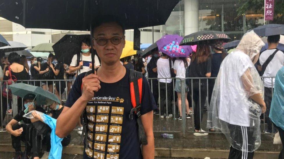 Mr Lee with umbrella among other demonstrators