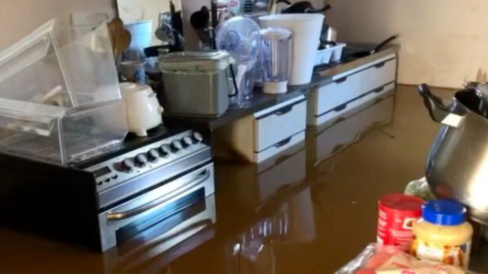 Flood water surrounding oven in a kitchen