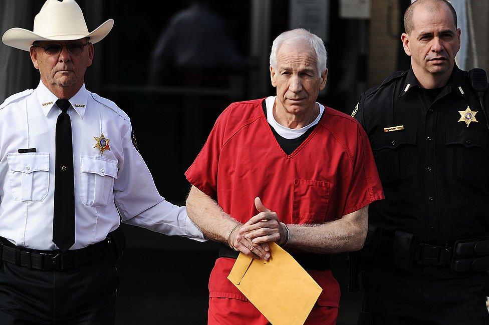 The elder Sandusky in handcuffs