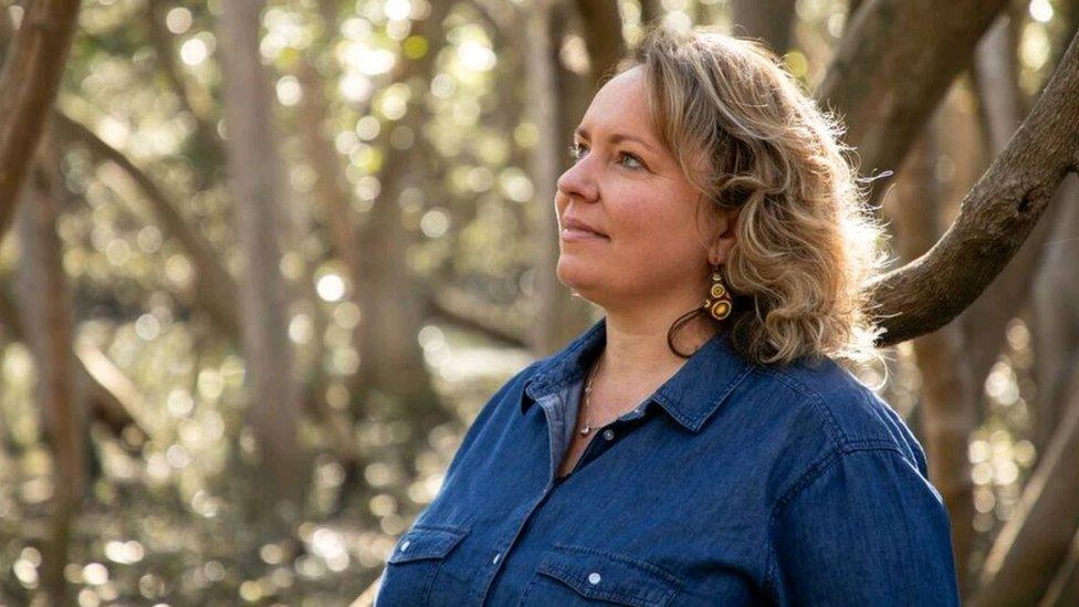 Shannon Foster stands in front of trees