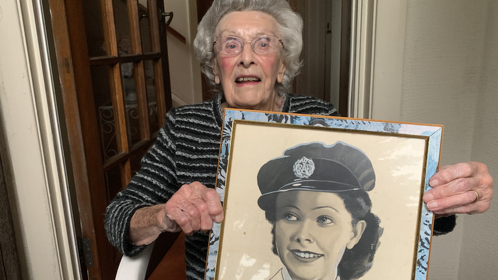 Jean McKay holding an old portrait of herself