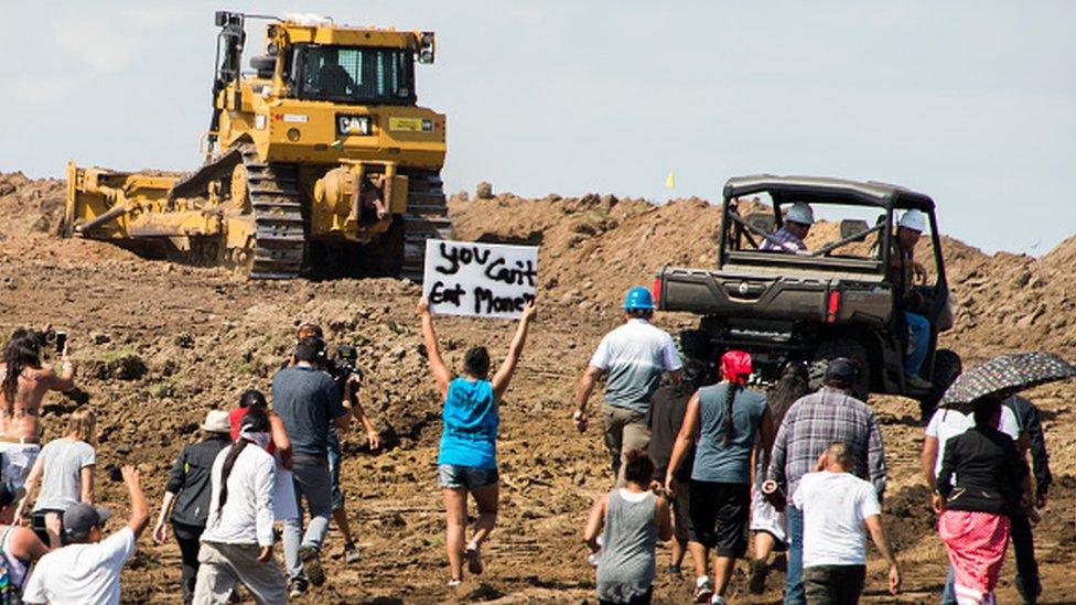 Native American protesters and their supporters are confronted by security during a demonstration against work being done for the Dakota Access Pipeline, North Dakota