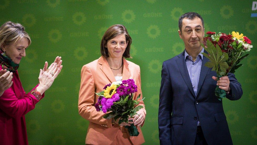 Katrin Göring-Eckardt (C) and Cem Özdemir hold flowers next to Federal chairwoman Simone Peters (L) at Green news conference in Berling (25 September)