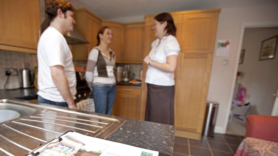 Couple being shown round a house