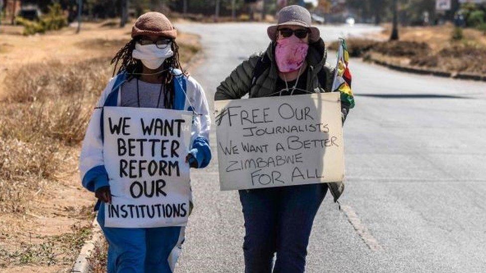 Zimbabwean novelist Tsitsi Dangarembga (L) and a colleague Julie Barnes hold placards during an anti-corruption protest march along Borrowdale road, on July 31, 2020 in Harare