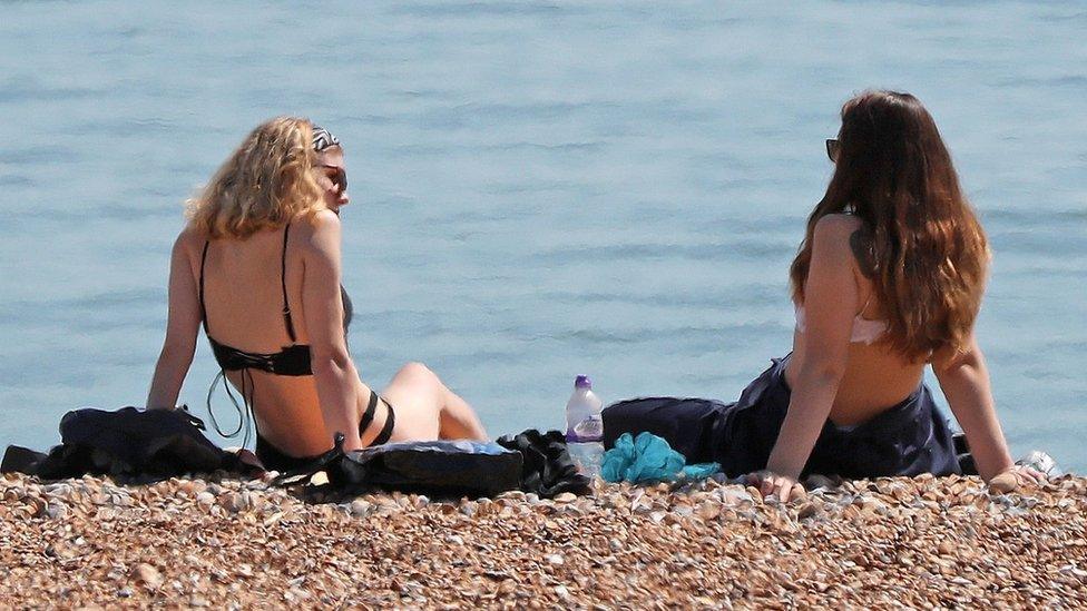 Two women relaxing on the beach in Hastings, East Sussex