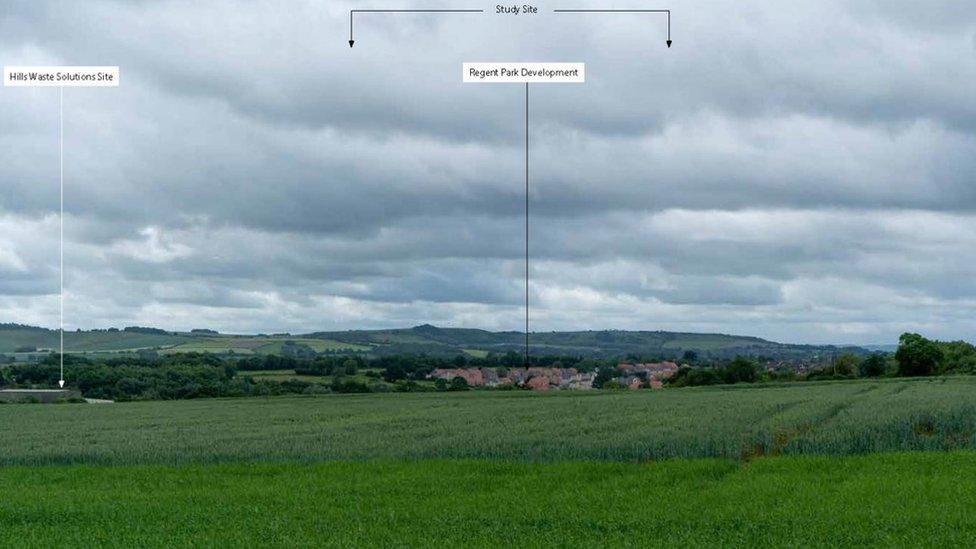 A large field with arrows pointing to where the development would have been built