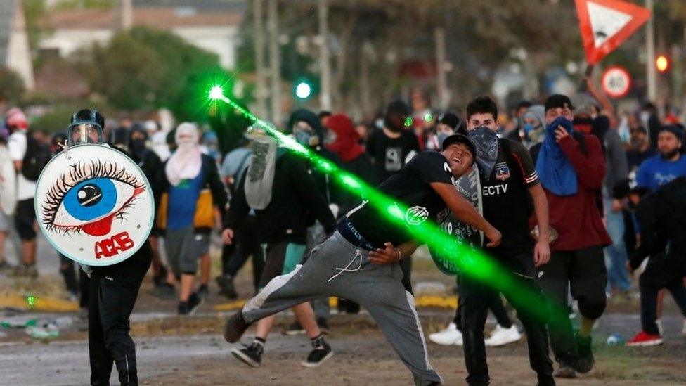 Demonstrators clash with riot police during a protest against Chile's government