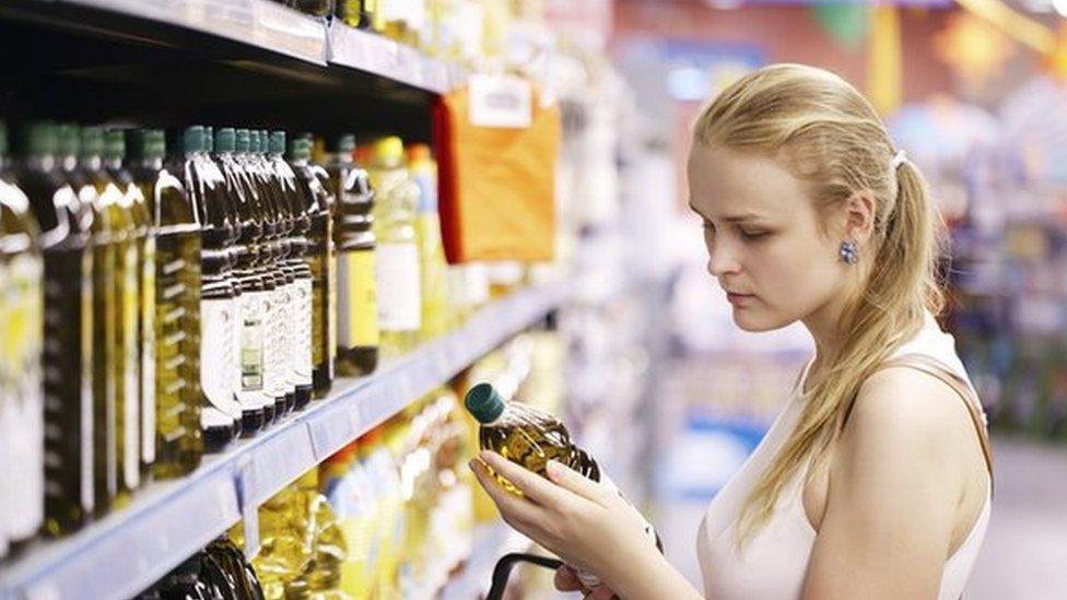 Woman checking price of cooking oil