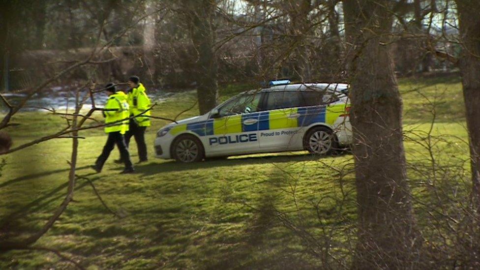 Police officers and a police car at the scene