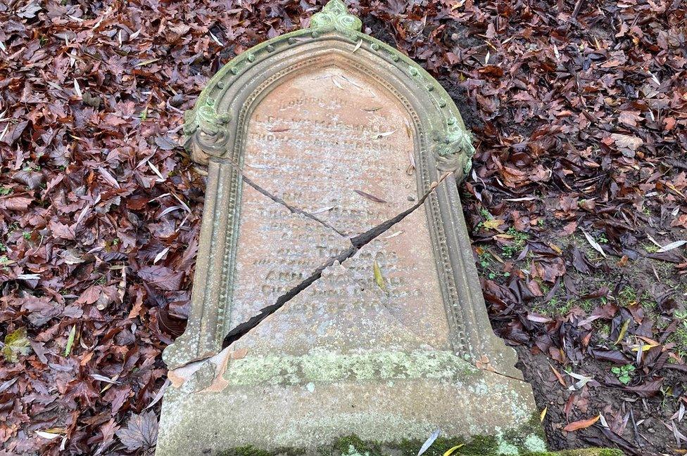 An old headstone cracked into four large pieces