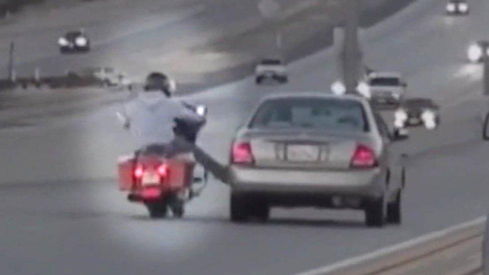 motorcyclist kicking car