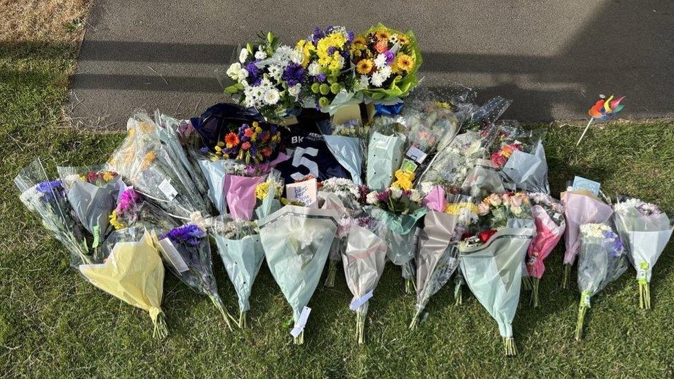 Flowers and a Number 5 football shirt at the club