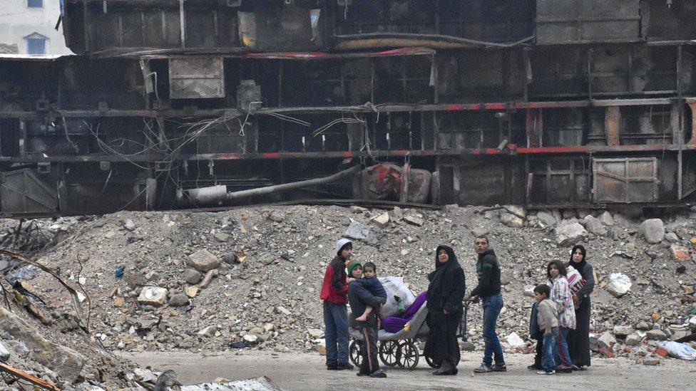 Syrian residents leave Aleppo's Bustan al-Qasr neighbourhood after pro-government forces captured the area in the eastern part of the war torn city on December 13, 2016. After weeks of heavy fighting, regime forces were poised to take full control of Aleppo, dealing the biggest blow to Syria's rebellion in more than five years of civil war.