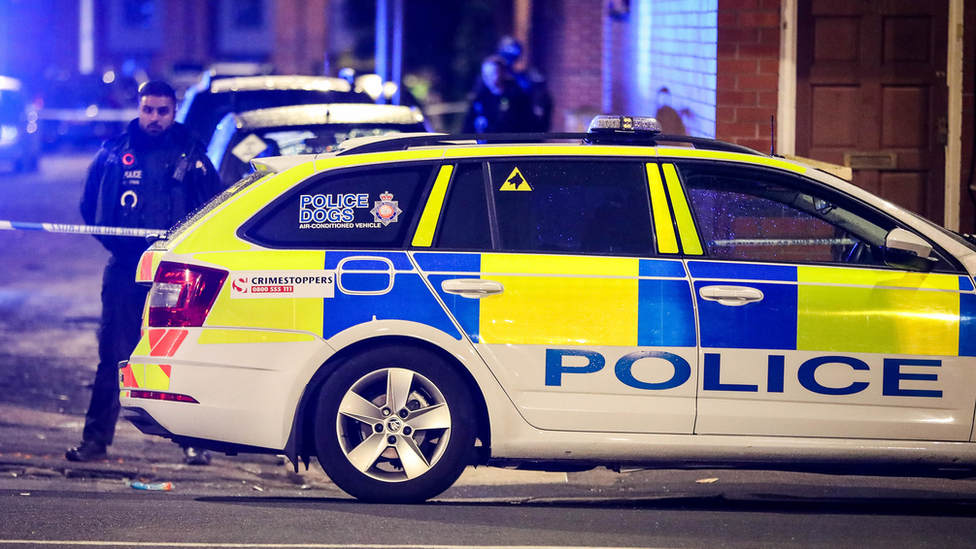 Police man and car at the scene of an illegal gathering