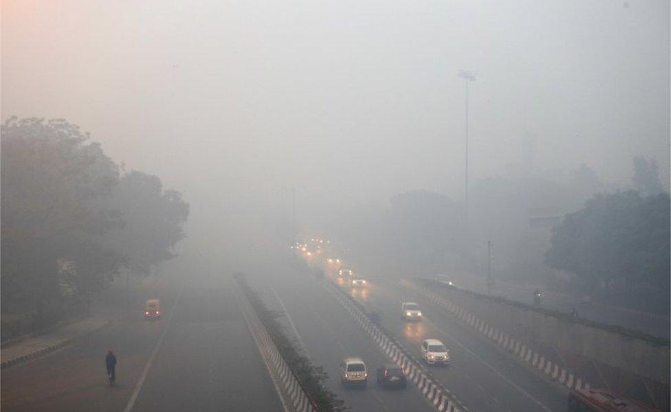 Traffic moves on a road enveloped by smoke and smog, on the morning following Diwali festival in New Delhi, India, Monday, Oct. 31, 2016.