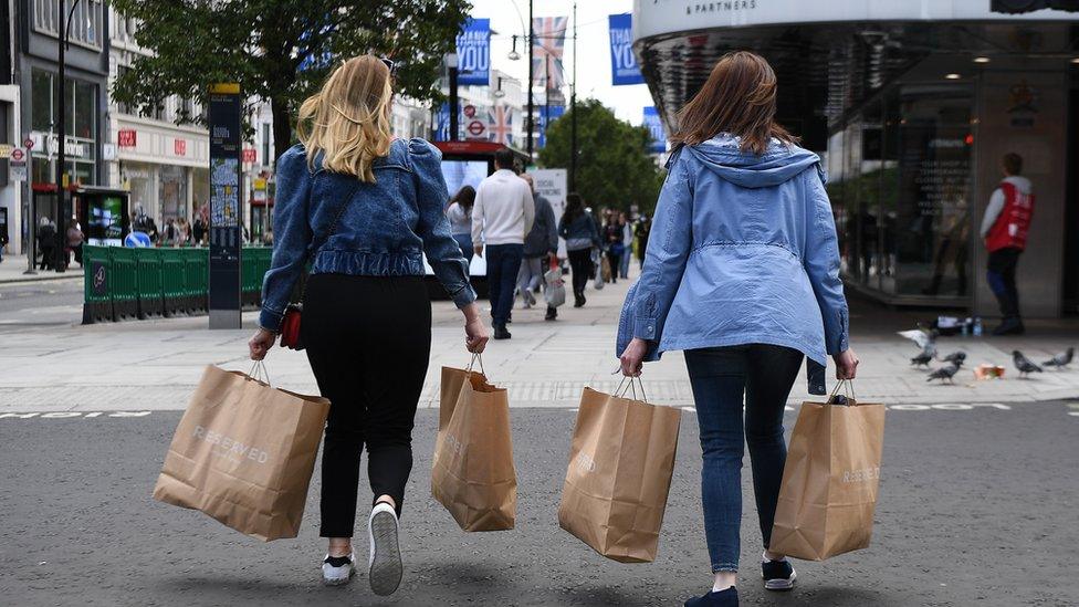 Shoppers with paper bags crossing road